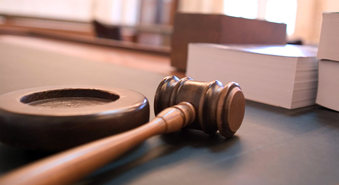a judge's gavel on a desktop with some large legal books